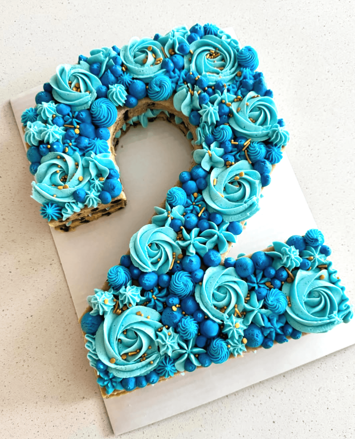 Number two-shaped cookie cake with blue rosettes